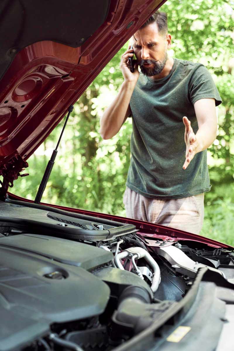 Junger Mann prüft Getriebeschaden bei Schrottauto Ankauf Hildesheim